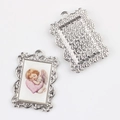 Macro view of vintage silver alloy angel pendant with embossed floral frame and textured back - Silver Base Heart Angel