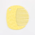 Close-up of yellow round portable comb with textured finish and hanging hole detail - Yellow