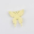 Makro-Detail eines creme-gelben Emaille-Schmetterlingsanhängers mit glatter Metalloberfläche - Hellgelb