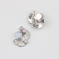 Macro detail of silver ginkgo leaf charms with white enamel and sparkling zircon inlay - Silver Base Pink Leaf