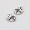 Close-up of silver rocking horse pendant with textured honeycomb surface and rhinestones - Silver