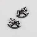 Close-up of gunmetal alloy rocking horse pendants with hammered texture for DIY jewelry making - Gunmetal