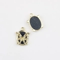 Macro view of gold alloy butterfly oval pendants with polished metal and matte resin - Gold Edge Black Base