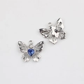 Détail macro du pendentif papillon avec pierre bleue en cœur et ailes en métal argenté - Base Argent Pierre Bleue