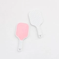 Close-up of pink and white silicone facial brushes with textured heads and non-slip handles - White Pink