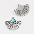 Macro view of vintage silver fan-shaped alloy pendant with turquoise stone inlay - Blue