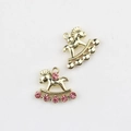 Detailed close-up of two golden rocking horse charms with pink rhinestones for DIY jewelry - Gold / Red