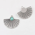 Macro detail of fan-shaped alloy charms with turquoise bead for DIY jewelry making - Blue Sodalite