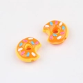 Nahaufnahme von orangefarbenen Acryl-Donut-Perlen mit bunten Streuseln für DIY-Schmuck - Gelb