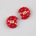 Macro shot of red acrylic cookie-shaped DIY charms with colorful dots and letter m - Red