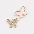 Macro detail of gold-plated butterfly charms with pink enamel and sparkling crystals - Gold Pink