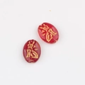 Close-up of red Czech glass oval beads with double-sided gold-gilded cat engravings - Transparent Red (00850501)