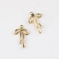 Detailed view of two gold bow pendants with green zircon inlay for jewelry making - Gold Green Zirconia