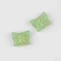 Macro shot of two mint green glass butterfly beads with detailed golden gilded edges - Emerald Green
