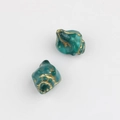 Macro shot of peacock green conch-shaped glass beads with vintage gold foil gilding - Malachite green