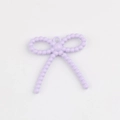 Detalle macro del colgante de lazo con cuentas lila para creación de joyas DIY - Púrpura