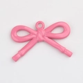 Detalle macro de un colgante de lazo rosa brillante con acabado de esmalte para joyas - Rosa Roja