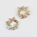Detail of enamel flower wreath pendants showing front blue star and back metal texture - Gold Base Blue Center