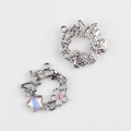 Dettaglio macro di ciondoli a ghirlanda con fiore rosa e stella iridescente per gioielli DIY - Base Argento Centro Rosa