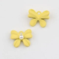 Detalle macro de colgantes de mariposa amarillos mate con perla para bisutería DIY - Amarillo