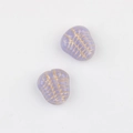 Dettaglio macro di perline in vetro ceco viola con incisione di trilobite dorata - Viola (01121001)