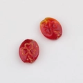 Close-up of Czech glass beads featuring red-orange gradient and gold clover embossing - Transparent Red