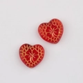 Macro detail of red heart-shaped Czech beads with vintage gold floral pattern for DIY jewelry - Transparent Red