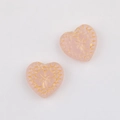 Detail of pink heart-shaped glass beads with gold clover patterns for DIY jewelry making - Pink