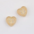 Macro shot of heart-shaped Czech glass beads with gold-trimmed honeycomb patterns - Clear