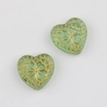 Close-up of green heart-shaped Czech beads with vintage gold floral patterns - Transparent Green
