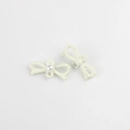 Detalle de colgantes de lazo blanco crema con textura de cuentas y perla central - Blanco lechoso