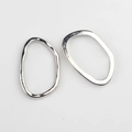 Vue macro d'anneaux ovales irréguliers en alliage d'argent poli pour la création de bijoux - Argent