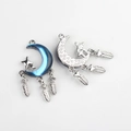 Detailed view of silver crescent moon charms with blue resin and feather tassels - Silver Base Blue
