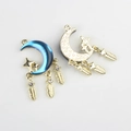 Detailed view of moon and star alloy charms with feathers and purple gradient finish - Gold Base Blue