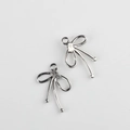 Detalle macro de colgantes de lazo plateado con circonitas para creación de joyas - Plateado Con Zirconia