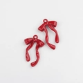 Detailed view of two dark red glossy alloy bow charms with metal rings for jewelry making - Red