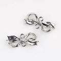 Detail view of silver metal bow pendants with double loops for DIY jewelry making - Silver