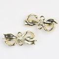 Macro detail of golden alloy bow charms with dual connecting rings for DIY jewelry - Gold