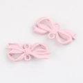 Macro detail of matte pink bow jewelry pendants with dual loops for DIY crafting - Pink