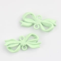 Detail of mint green matte bow pendant with dual hanging loops for DIY jewelry - Green