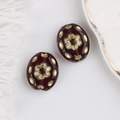 Close-up of vintage deep red glass beads with intricate gold floral patterns and motifs - Reddish Brown
