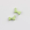 Detail of light green bone-shaped alloy pendant with paw print for DIY jewelry making - Green