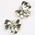 Detail of two gold-colored bow charms with hanging holes for DIY jewelry making - Gold
