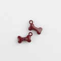 Macro detail of red bone charms with paw print for DIY jewelry making - Dark Red