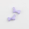 Macro shot of two bone-shaped lavender enamel pendants with paw print for DIY jewelry - Purple
