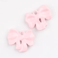 Close-up of pink enamel bow pendant charms for DIY jewelry making accessories - Pink