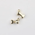 Macro shot of two golden bone charms with paw print engraving for DIY jewelry making - Gold