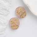 Detailed view of pink glass skull beads with gold-painted engravings for DIY jewelry - Pink