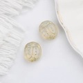 Macro shot of two Czech glass ladybug beads with hand-painted gold details for jewelry - Clear