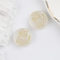 Macro detail of round white glass beads with gold painted cat designs for DIY jewelry - Jade White